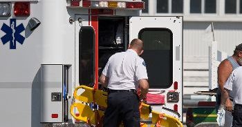 Emergency responder removing a stretcher from an ambulance.