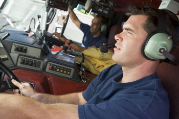 Two firemen in fire engine (selective focus)