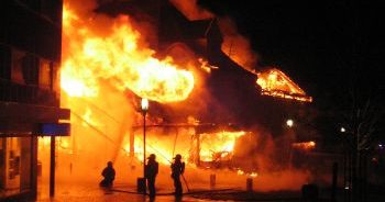 Firefighters fighting fire outside a burning building