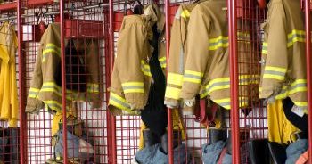Fire department facility with equipment hanging in lockers.