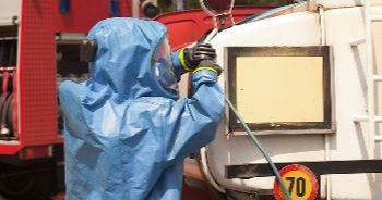 Emergency responder adjusting equipment on a fire truck.